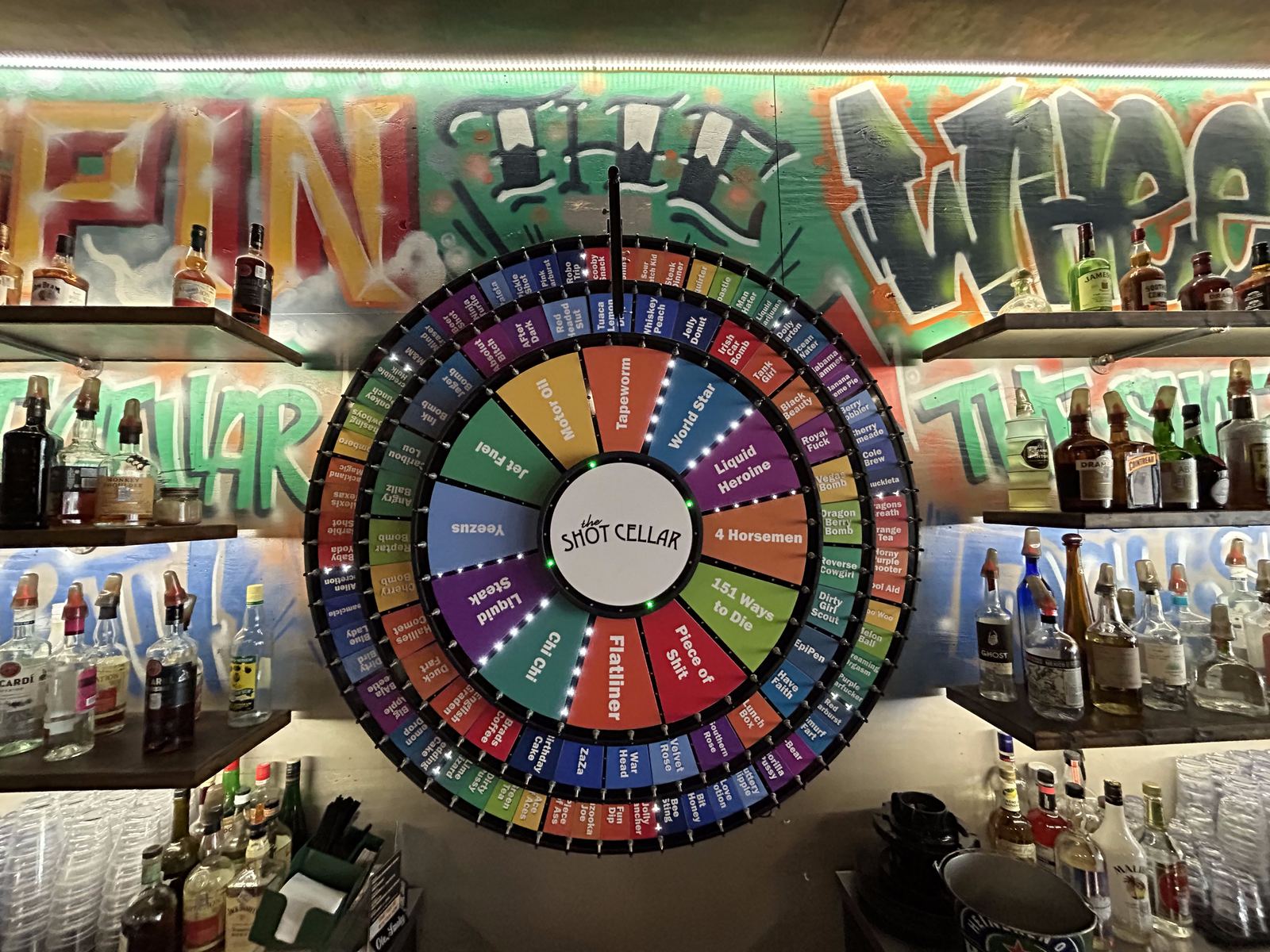 The shot wheel photographed from an angle against the bar's graffiti wall