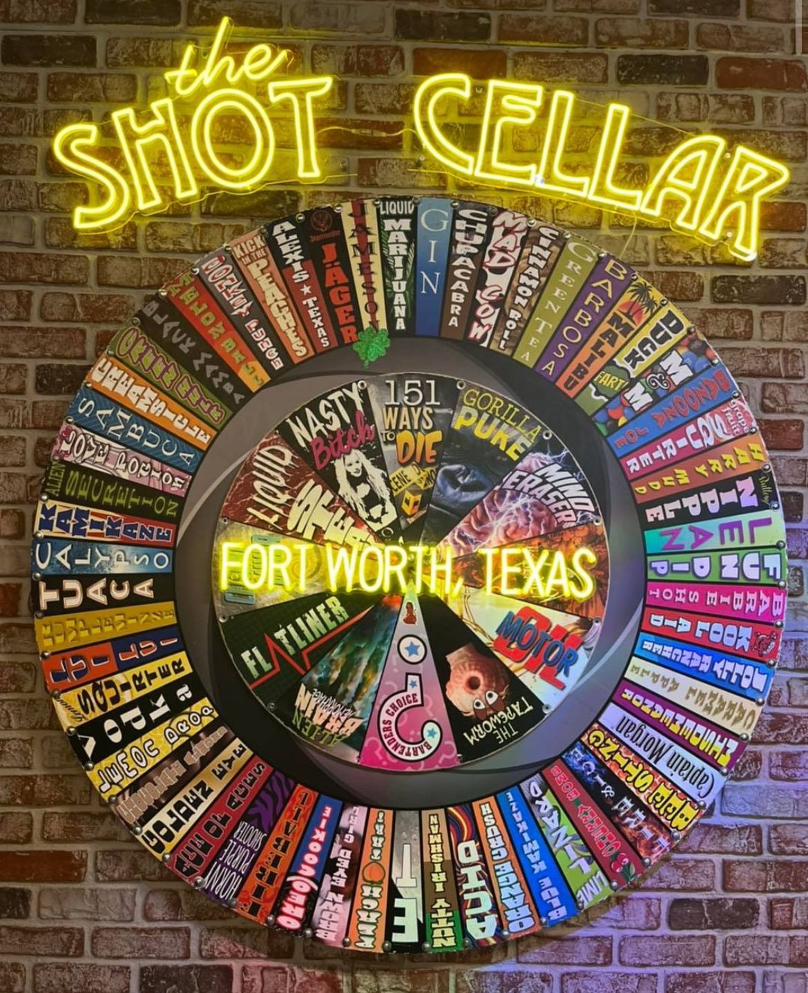 The original hand-painted shot wheel, now hanging on the wall under a neon sign