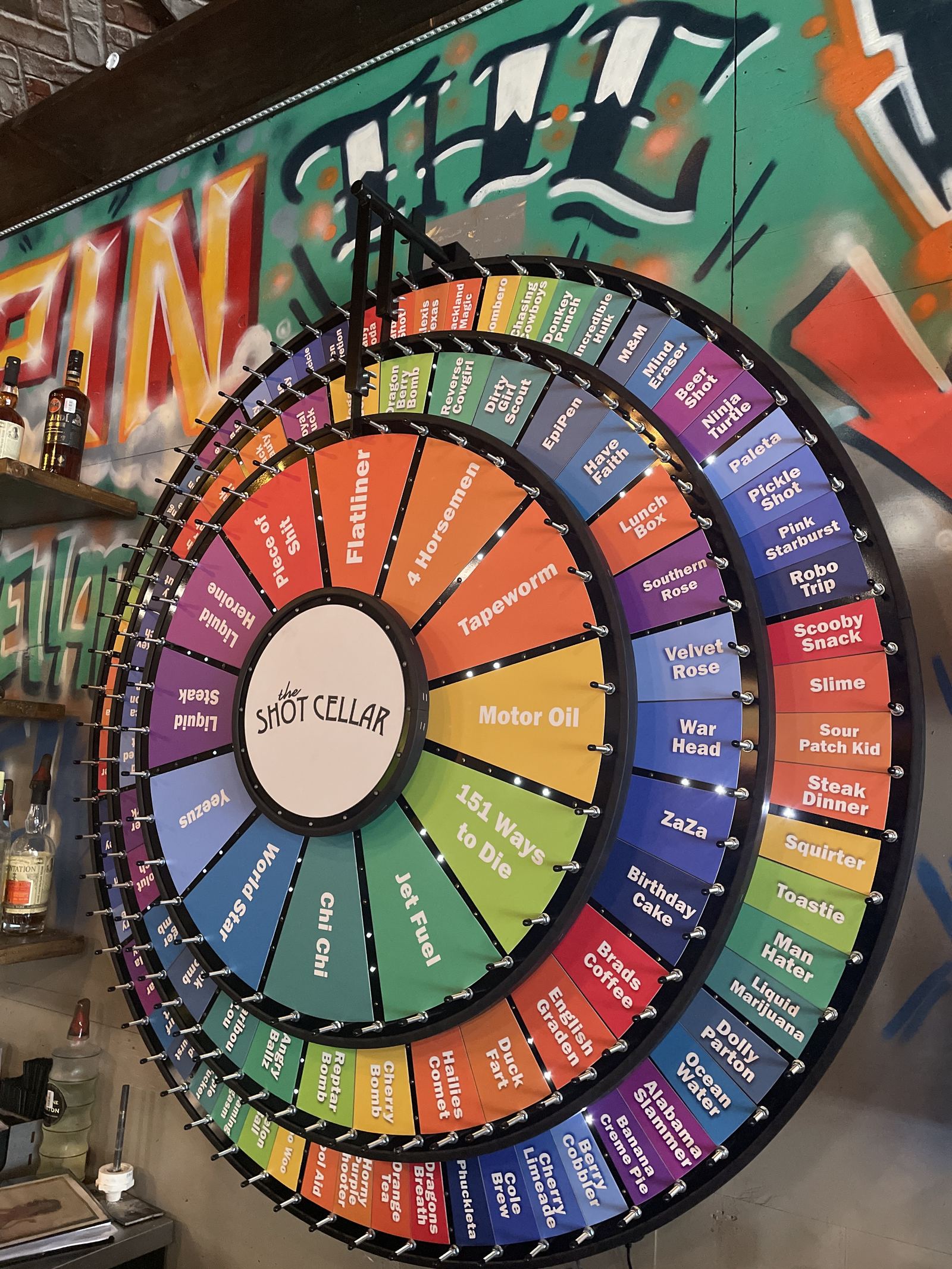 Close on The Shot Cellar's three-tier shot wheel: Flatliner, Motor Oil, 151 Ways to Die, Liquid Heroine and dozens more named around the rings